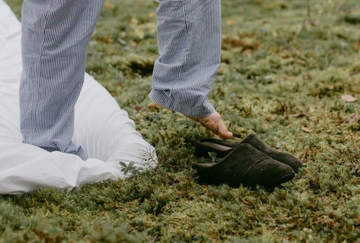 A person steps into slippers outdoors, embracing a cozy morning vibe.